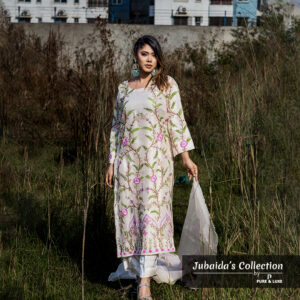 Model wearing an ivory embroidered muslin-silk 3-piece suit with pink and green floral patterns, part of Jubaida’s Collection by Pure & Luxe, standing in a natural outdoor setting.