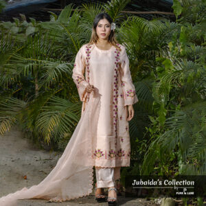 Woman wearing a blush pink embroidered muslin-silk 3-piece suit with floral detailing, holding a scalloped dupatta, standing in a garden setting.