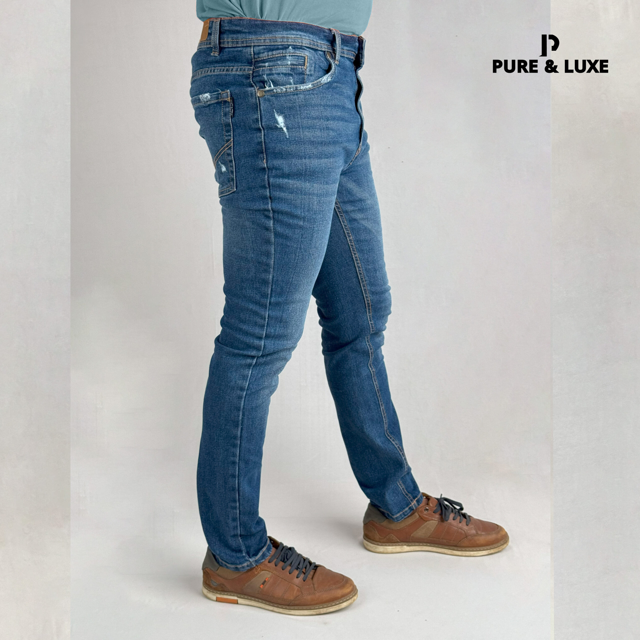 Man wearing Hard Grind Indigo Slim Fit Jeans by Pure & Luxe – right leg view