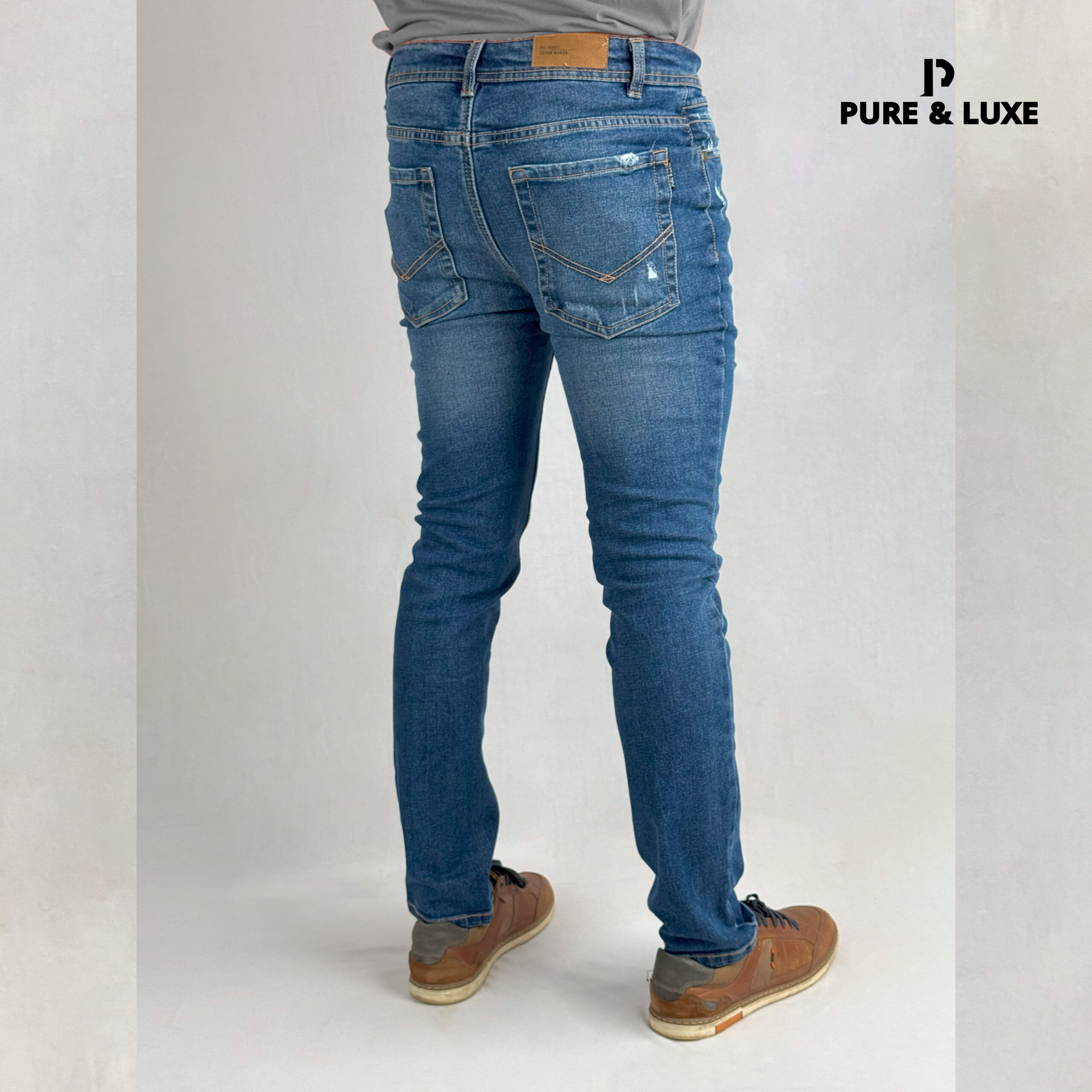 Man wearing Hard Grind Indigo Slim Fit Jeans by Pure & Luxe – back view
