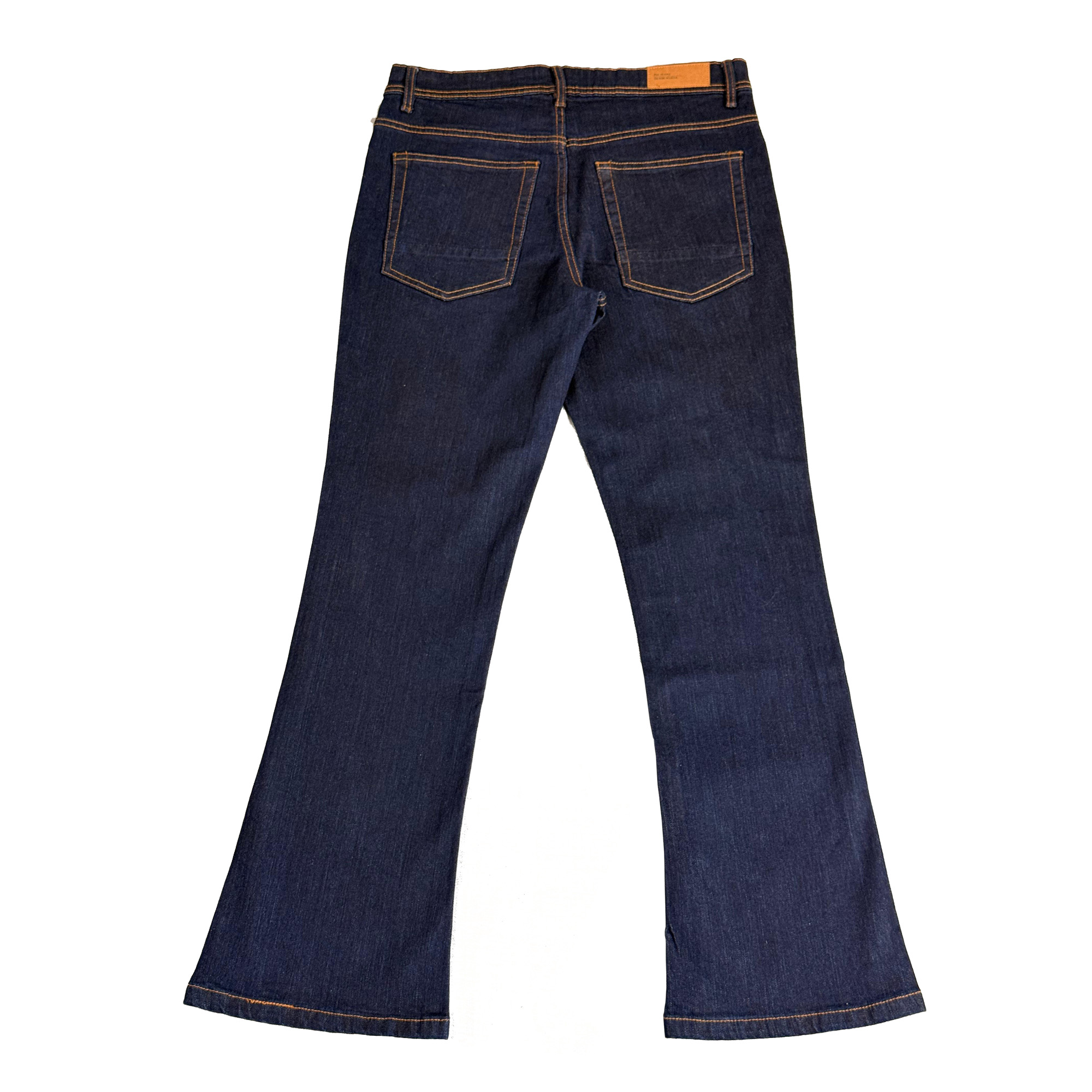 Flat lay view of the back of Indigo Rinse Bootcut Jeans, displaying the brand's signature pocket stitching and the durable 98% cotton fabric texture.
